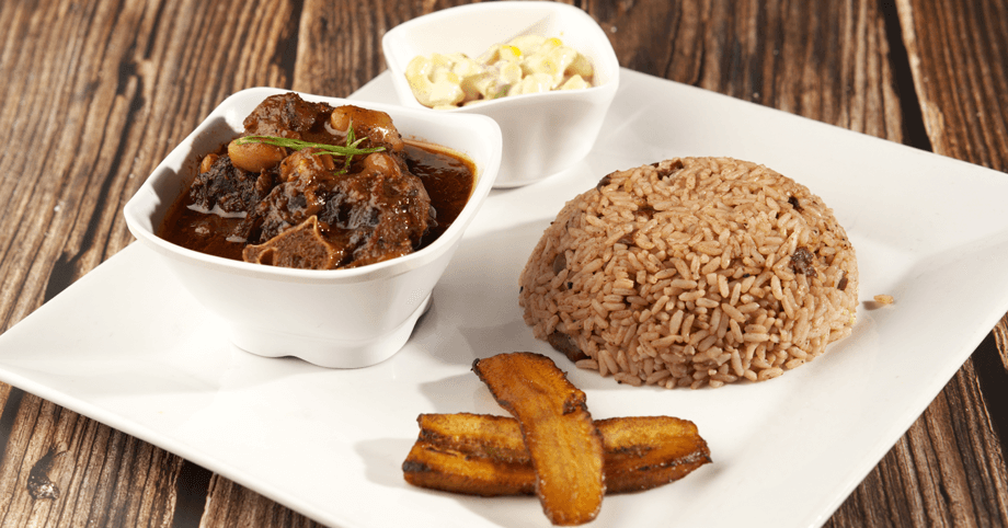 Enjoy a flavorful Jamaican dish – oxtail with rice, peas, plantain, and macaroni salad Savory oxtail served with traditional rice and peas, plantain, and macaroni salad
