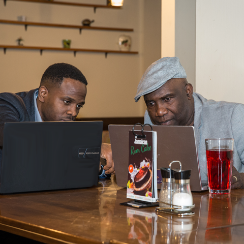 Click to view full image of a business meeting over drinks Two professionals enjoying drinks while working on laptops – thumbnail view